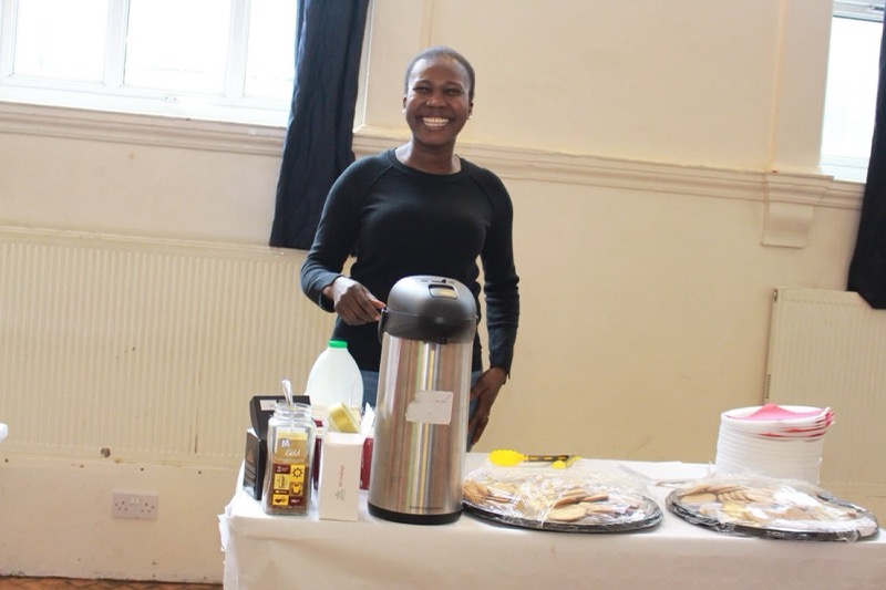 A volunteer serving hot drinks and food at the Easter Charity Event